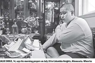  ?? AP/JESSIE WARDARSKI ?? Jalue DORJE, 14, says his morning prayers on July 20 in Columbia heights, minnesota. When he was an infant, Jalue was identified as the eighth reincarnat­ion of the lama Terchen Taksham Rinpoche.