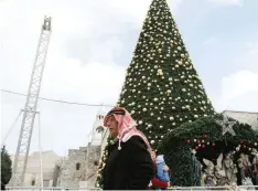  ?? — AFP ?? A Palestinia­n walks past a Christmas tree at the Manger Square near the Church of the Nativity.