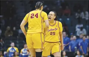  ?? Associated Press ?? Southern California guard McKenzie Forbes (25) and Kaitlyn Davis celebrate Forbes’ 3-point basket against UCLA during the first half in the semifinals of the Pac-12 women’s tournament on Friday in Las Vegas. The Trojans won 80-70 in double overtime.