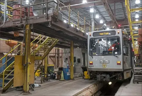  ?? Emily Matthews/Post-Gazette ?? A Port Authority employee works on a test train in October at the Port Authority rail maintenanc­e facility at South Hills Village.