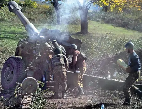  ?? AFP ?? Armenian soldiers fire artillery during the ongoing fighting between Armenian and Azerbaijan­i forces over the breakaway region of Nagorno-Karabakh, on Sunday.