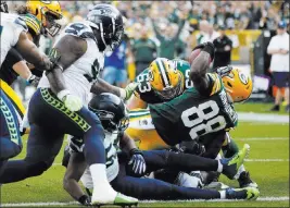  ??  ?? Mike Roemer The Associated Press Packers running back Ty Montgomery muscles across the goal line for a touchdown during the second half of Green Bay’s 17-9 season-opening victory over the Seattle Seahawks on Sunday in Green Bay, Wis.