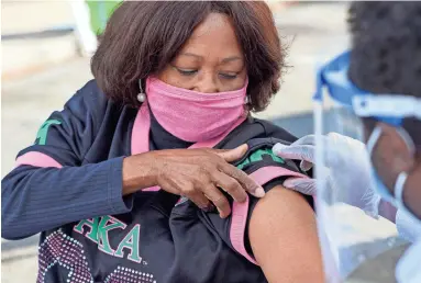  ?? DRAKE PRESTON/THE REPUBLIC ?? Brenda Hanserd receives the COVID vaccine from pharmacist Tesfu Telinte in Phoenix in March.