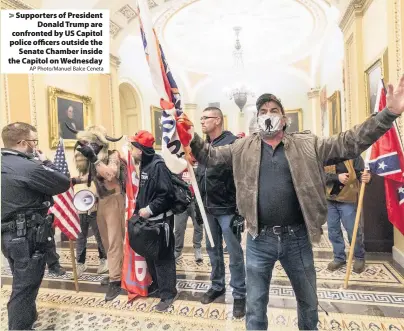  ?? AP Photo/Manuel Balce Ceneta ?? Supporters of President Donald Trump are confronted by US Capitol police officers outside the Senate Chamber inside the Capitol on Wednesday