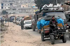  ?? AP ?? Syrians drive through the city of al-Mastouma, in Idlib province, as they flee a government offensive.