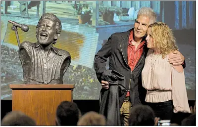  ?? NWA Democrat-Gazette/DAVID GOTTSCHALK ?? Amy Helm, daughter of musician Levon Helm, and artist Kevin Kresse unveil a bronze bust of her late father Friday in downtown Fayettevil­le.