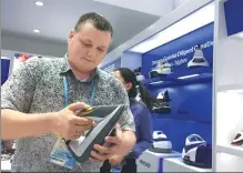  ?? QIU QUANLIN / CHINA DAILY ?? A foreign merchant tries a steam iron at the Canton Fair, which ended on Friday in Guangzhou, Guangdong province.