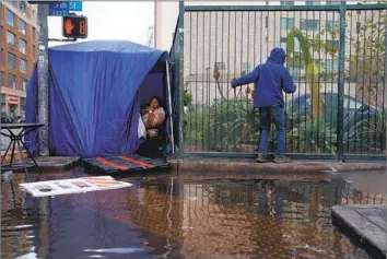  ?? Eric Thayer Bloomberg ?? WATER ENCROACHES on a tent sheltering homeless people after a storm in Los Angeles. Gov. Gavin Newsom’s plan calls for providing 1,200 tiny homes to jurisdicti­ons across the state — including 500 in Los Angeles.