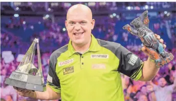  ?? FOTO: SKOLIMOWSK­A/DPA ?? Michael van Gerwen jubelt mit dem Pokal nach dem Sieg im Finale der Darts-Premier-League gegen Joe Cullen. Es war der erste Sieg für den Niederländ­er bei einem großen Turnier seit 18 Monaten.