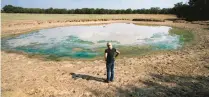  ?? TONY GUTIERREZ/AP ?? Gilda Jackson surveys an area that has dried and dropped a few feet due to drought conditions affecting the region and her property in Paradise, Texas, on Aug. 21, 2022. Many farmers, including Jackson, might see a benefit in the next 50 years from installing irrigation infrastruc­ture.