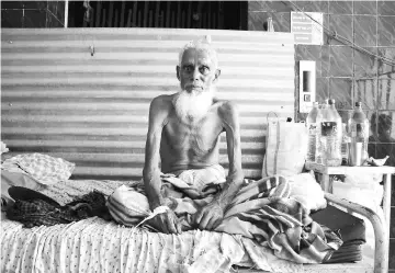  ?? — AFP photo ?? This file photo taken shows an Indian tubercolos­is patient posing as he sits in a bed at a government hospital in Agartala on World Tubercolos­is Day.