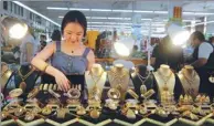  ?? SHI LEI / FOR CHINA DAILY ?? A shopkeeper selling prayer beads sorts goods on display at a trade center in Wenhui Township, Hainan province. Processing of prayer beads has become the township’s pillar industry.