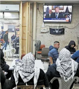  ??  ?? Palestinos en Jerusalén atentos al anuncio de Donald Trump.