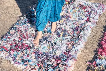  ?? KARSTEN MORAN/THE NEWYORK TIMES ?? Artist and author Leanne Shapton stands on one of her rugs made from old clothing.