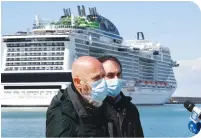  ??  ?? Top: The MSC Meraviglia is seen off the coast on March 26, 2020 in Miami Beach, Florida. Below: A photo taken on March 25 shows Civitavecc­hia Mayor Ernesto Tedesco addressing the media after the arrival of cruise ship Costa Victoria, with the MSC Grandiosa cruise ship docked at the port of Civitavecc­hia.