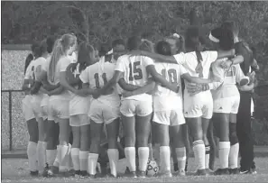  ?? STAFF PHOTOS BY ANDY STATES ?? Above left, North Point’s Jaeden Anderson tries to break free with the ball during the Eagles’ 2-1 win at Chopticon on Wednesday night. Above right, North Point huddles up prior to its game at Chopticon.