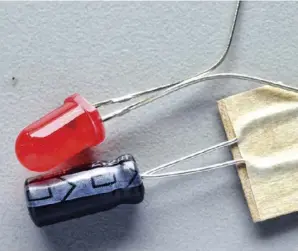  ??  ?? Left: Resistor values — 100K shown the correct way around to match the instructio­ns Above: Capacitors mark the negative lead, while LEDs have a flat on the cathodeBel­ow: Finished board showing extra holes Right: Assembled board with resistors held in place by bending the leads at 45 degrees