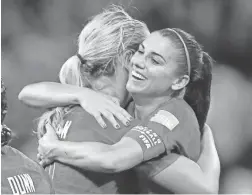  ?? MICHAEL CHOW/THE REPUBLIC ?? United States forward Alex Morgan (right) hugs midfielder Lindsey Horan after the Americans defeated England on Tuesday.