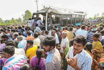  ?? PTI ?? Above: People gather near the site where a private bus fell into a canal in Mandya district, Karnataka, yesterday. Rescue operations were still underway to search for the remaining victims.