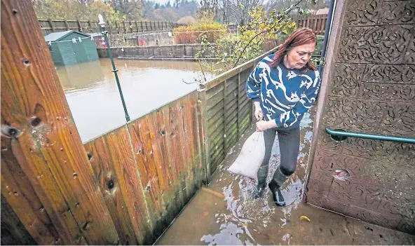  ?? ?? BATTLE: Kim Clark, of River Street, Brechin, tackles flooding as locals say they were left to fight for themselves. Picture by Mhairi Edwards.