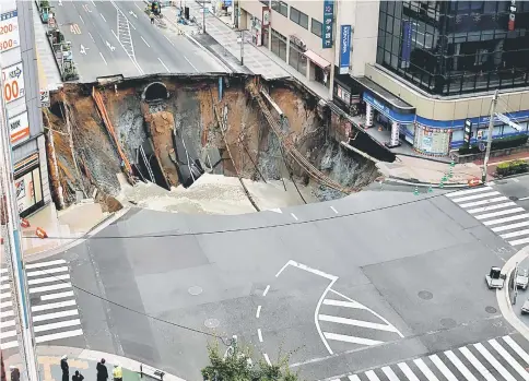  ??  ?? A huge sinkhole is seen at an intersecti­on near Hakata station in Fukuoka, Japan. — Reuters photo