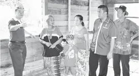  ??  ?? RADIN berbual dengan Ana yang menerima bantuan baikpulih rumah usang di Kampung Makakumpai.