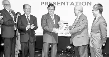  ??  ?? Manyin (second right) presents a memento to Abang Johari. — Photo by Chimon Upon