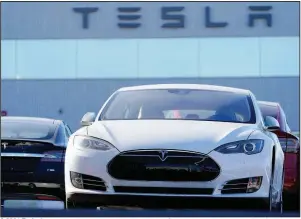  ?? (AP/David Zalubowski) ?? A 2021 Tesla S70 sedan sits at a dealership in Littleton, Colo., last month. A streak of profitable quarters has helped push the company’s stock price up more than 700% this year.