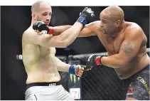  ??  ?? DANIEL CORMIER (red gloves) fights Volkan Oezdemir (blue gloves) during UFC 220 at the TD Garden.