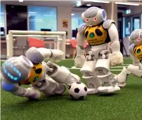  ?? AFP ?? Robots battle it out for the soccer ball in Sydney on Friday as part of training for the upcoming RoboCup in Japan. —