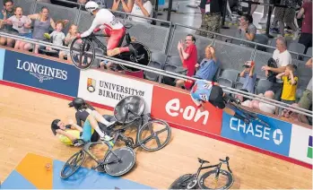  ?? Photo / AP ?? England’s Matt Walls hurtles over the barrier and into fans as Kiwi George Jackson and Aussie rider Josh Duffy skate across the track.