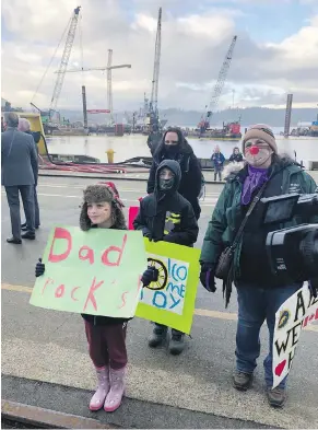  ?? TIMES COLONIST ?? Athena Stone and Ethan Stone hold signs to welcome their dad, Andy, back home after a mission on HMCS Winnipeg. With them is grandmothe­r Therese Stone, right, and mom Melissa.