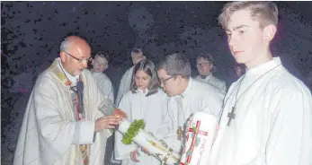  ?? FOTO: JOSEF SCHNEIDER ?? Pater Tadeusz Trojan entzündet bei der Feier der Osternacht auf dem Schönenber­g die Osterkerze.