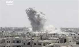  ??  ?? DAMASCUS: This frame grab from video provided yesterday by the Ghouta Media Center, a Syrian activist media group, shows smoke and debris rising after a Syrian government groundto-groundrock­et strikes the opposition-held town of Ain Terma. — AP