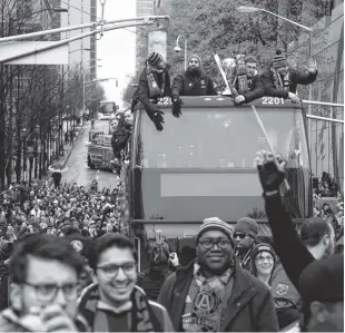  ?? BOB ANDRES/ATLANTA JOURNAL AND CONSTITUTI­ON VIA AP ?? Fans cheer as a double-decker bus carrying the Atlanta United FC MLS team passes during the team’s victory parade in Atlanta on Monday. Atlanta United defeated the Portland Timbers 2-0 in the MLS Cup on Saturday night.