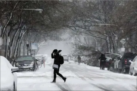  ?? KIICHIRO SATO — THE ASSOCIATED PRESS ?? A commuter walks to a bus stop as snow falls, Monday in Chicago. A wintry storm brought blizzard-like conditions to parts of the Midwest early Monday, grounding hundreds of flights and causing some road traffic chaos as commuters returned to work after the Thanksgivi­ng weekend.