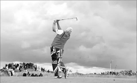  ?? — Photo by The Associated Press ?? John Daly plays a shot off the fifth tee at Royal Lytham & St Annes golf club during the second round of the British Open Friday. Daly will get to fly the flag another couple of days — he made the cut, although just barely.