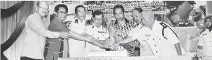  ??  ?? RAIKAN BERSAMA: Dr Abdul Rahman (lima kiri) bersama Selamat (dua kiri), Dr Chan (empat kiri), Chew dan Omar (kanan) memotong kek bersama ahli jawatankua­sa tertinggi PBSM Limbang.