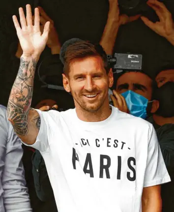  ?? Foto: Sameer Al‰Doumy, dpa ?? Nicht einmal 48 Stunden nach seinem Tränen‰Abschied präsentier­t sich Messi den Fans seines neuen Klubs und zeigt mit seinem T‰Shirt auch gleich, für wen sein Herz künftig schlägt.