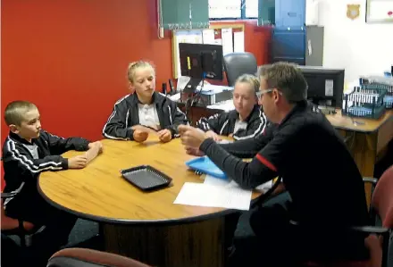  ?? SUPPLIED ?? Pukeokahu School pupils present questions to Taihape New World manager Adrian Rees about their use of plastic bags.