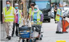  ?? South China Morning Post ?? A cleaner hauls a trolley in Jordan, Hong Kong. Researcher­s say their new motorized trolleys can help workers transport heavy loads easily.