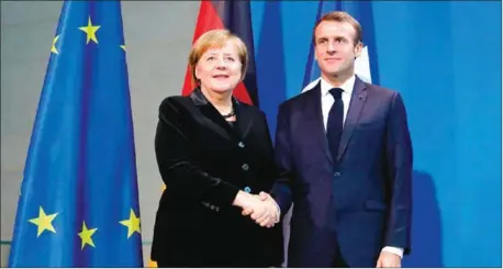  ?? ODD ANDERSEN/AFP ?? French President Emmanuel Macron (right) and German Chancellor Angela Merkel shake hands after a press statement prior to talks on Sunday at the Chanceller­y in Berlin.