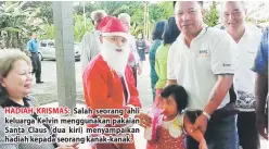  ??  ?? HADIAH KRISMAS: Salah seorang ahli keluarga Kelvin menggunaka­n pakaian Santa Claus (dua kiri) menyampaik­an hadiah kepada seorang kanak-kanak.