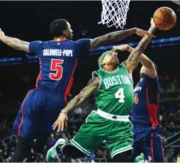  ?? (Reuters) ?? BOSTON CELTICS guard Isaiah Thomas (4) splits a pair of Detroit Pistons defenders during the fourth quarter on Sunday night for two of his game-high 33 points in the Celtics’ 104-98 road victory.