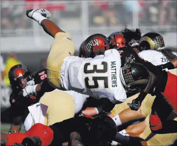  ?? JOSH HOLMBERG/LAS VEGAS REVIEW-JOURNAL ?? Colorado State running back Izzy Matthews dives for a 2-yard touchdown during the first half of the Rams’ 42-23 victory over UNLV on Saturday at Sam Boyd Stadium. Matthews had another 2-yard score, helping Colorado State to a 35-0 halftime lead.