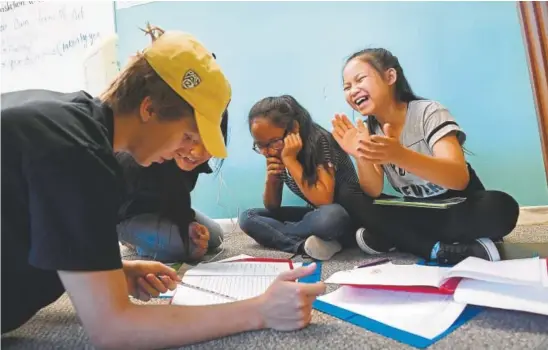  ?? Helen H. Richardson, The Denver Post ?? From left, volunteer youth counselor Connor Jones, 20, helps 11-year-olds Sarah, Sher Deh and Yeh Doh work on a bilingual ebook during a summer day camp at the nonprofit Village Exchange Center in Aurora, where 19.5 percent of the residents in 2017...