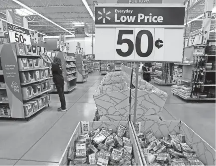  ?? RICK WOOD / MILWAUKEE JOURNAL SENTINEL ASSOCIATED PRESS ?? An employee at the Walmart in Greendale arranges back-to-school items in August 2019 as students and their parents show up to buy school supplies.