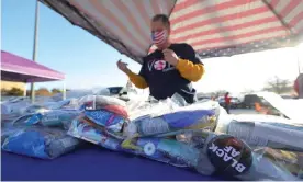  ?? Photograph: Michael M Santiago/Getty Images ?? A volunteer distribute­s voter care packages in Hephzibah, Georgia, ahead of the runoff election.