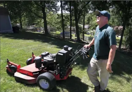  ?? ORLIN WAGNER — THE ASSOCIATED PRESS ?? In this Monday photo, Jake Wilson, owner of Top Class Lawn Care, talks with a client while on a job in Kansas City, Mo. Wilson is on the fence about his 5-year-old company and whether he should add to his staff of three and buy another truck. Wilson is concerned that if he does expand, he won’t be giving his customers the kind of service he does now.