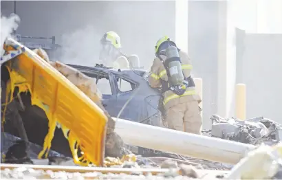  ?? Picture:EPA ?? AFTERMATH. Emergency services personnel are seen at the scene of yesterday’s plane crash in Essendon, Melbourne, Australia. Five people were on board the light plane that crashed into a shopping centre.